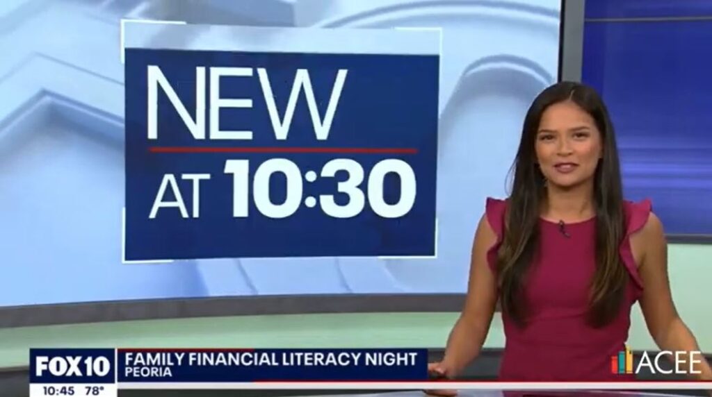 News anchor sitting behind a desk with text "Family Financial Literacy Night - Peoria" and Fox 10 news logo