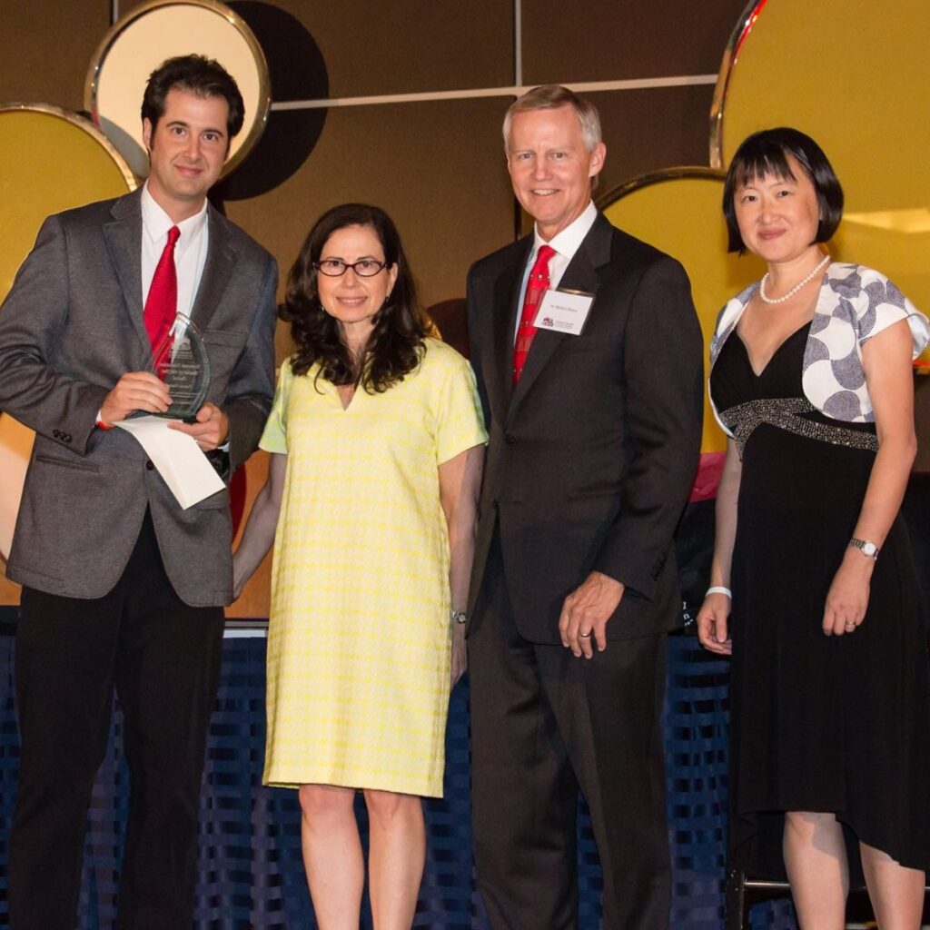 Photo of Travis Klein receiving an award with Elena Zee and Nan Morrison.