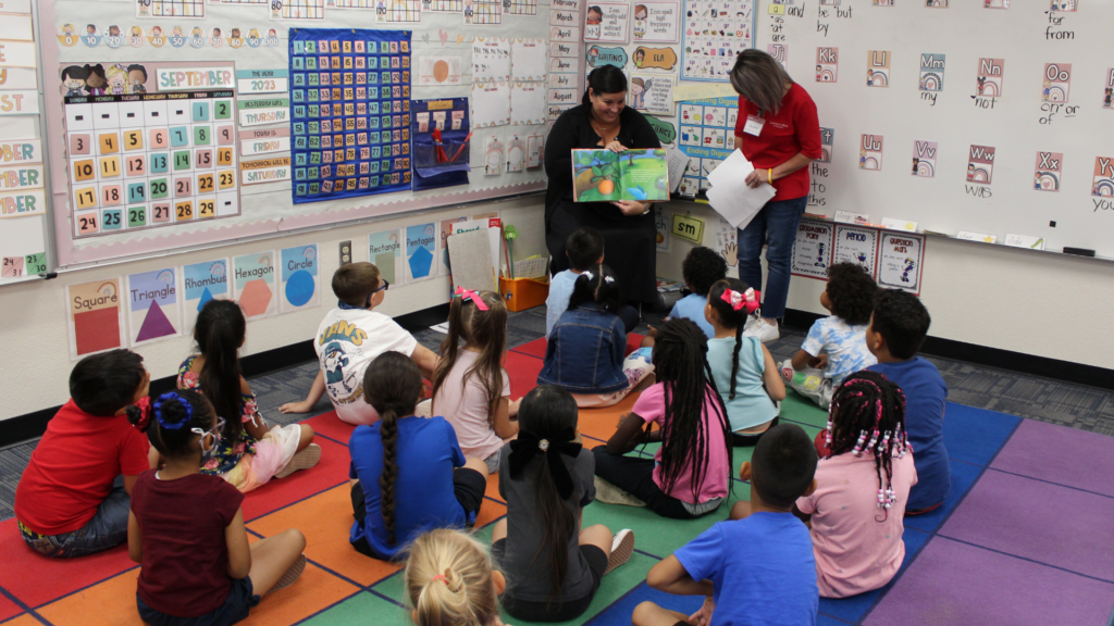 Volunteers reading to an elementary class.